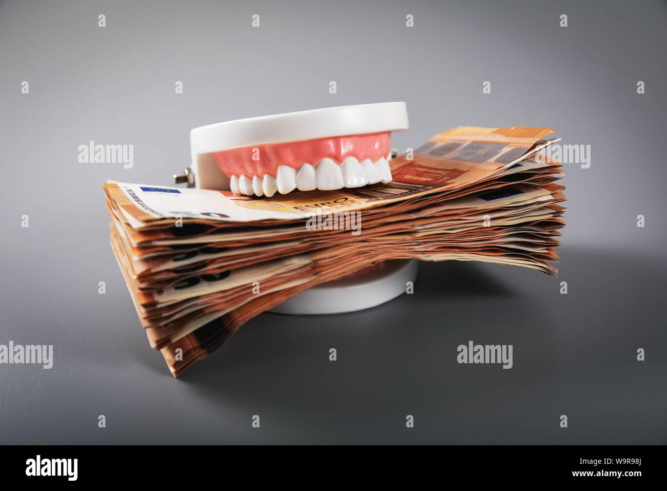 Concepto de la codicia - dientes modelo monetario en euros comer facturas Foto de stock