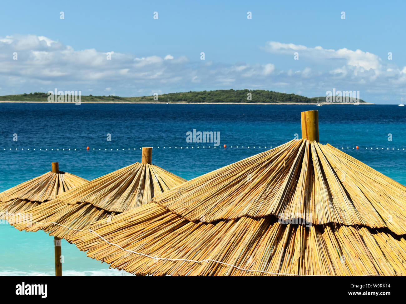 Sombrillas en turquesa playa adriática. Foto de stock
