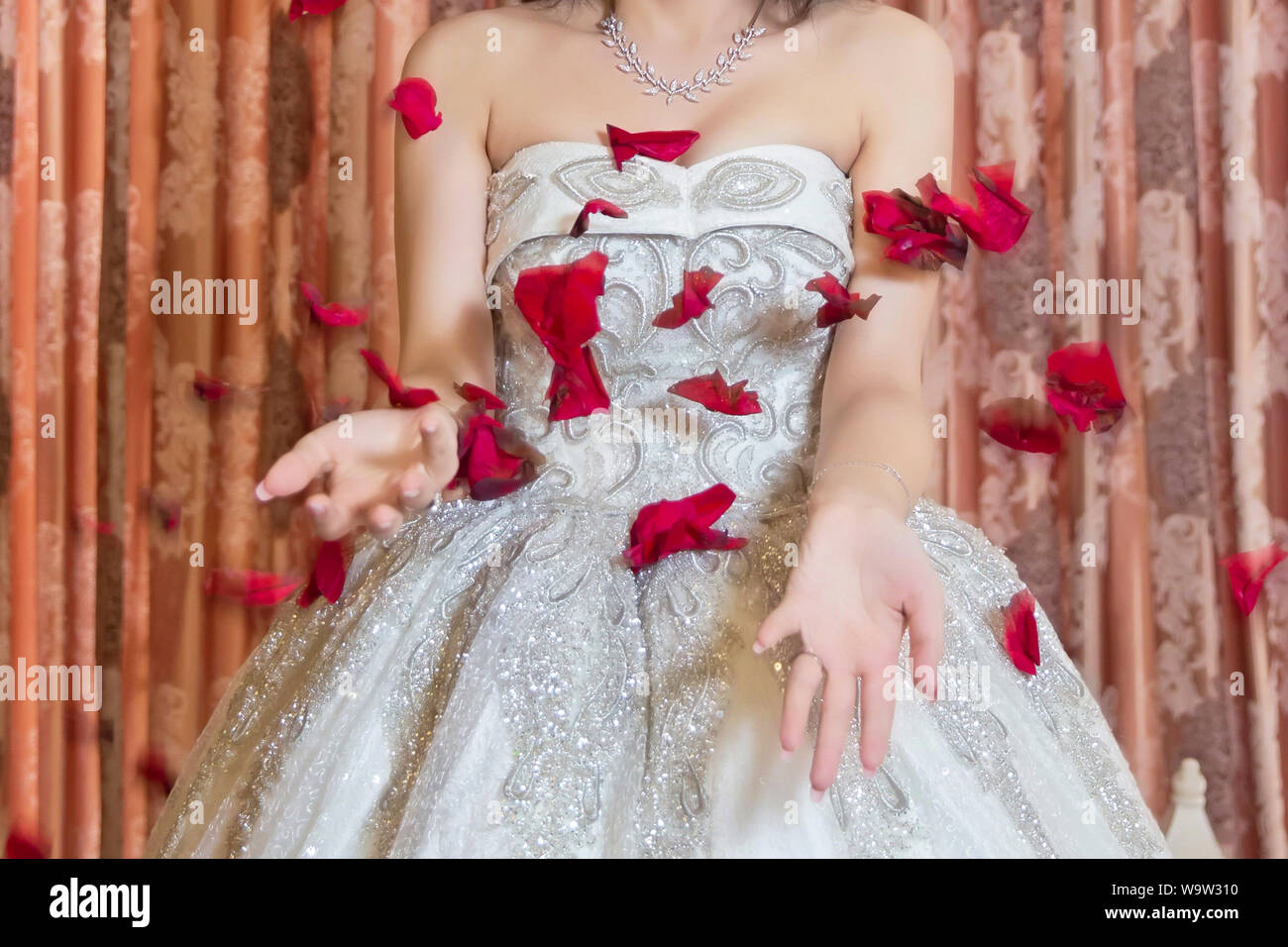 La novia lanza pétalos rojos . Pétalos de rosas rojas caen en la feliz  novia Fotografía de stock - Alamy