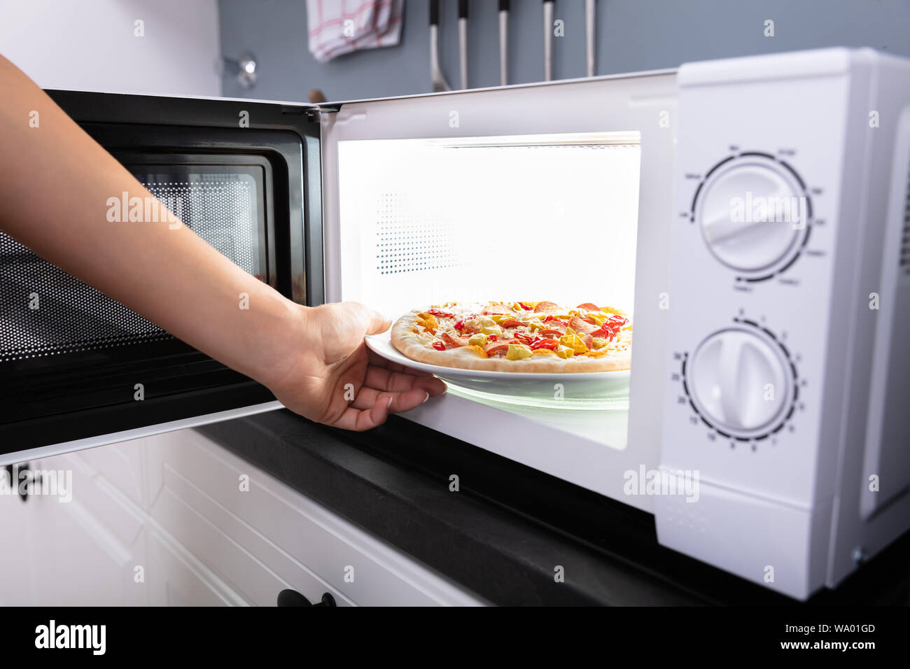 Close-up de una mujer alegre y hornear pizza en horno microondas Fotografía  de stock - Alamy