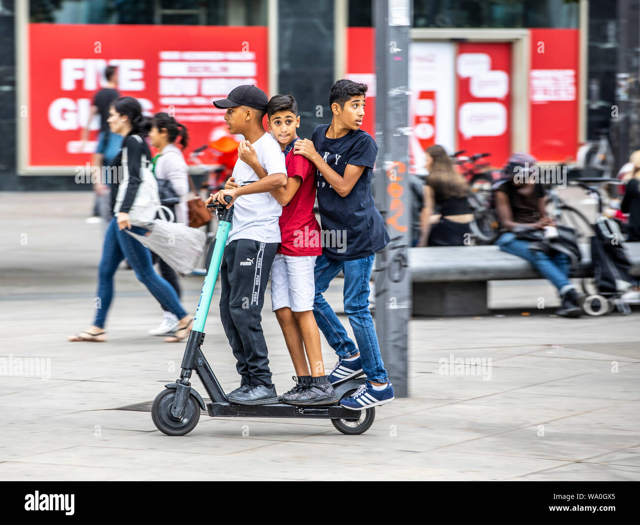 E-scooter, scooter eléctrico, alquiler de scooter, conducir a Alexander  Platz, en Berlín, 3 personas en una scooter Fotografía de stock - Alamy