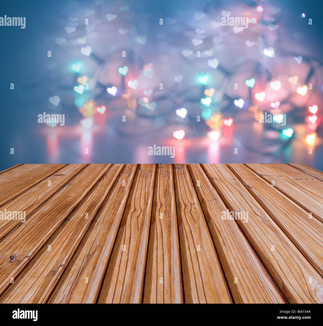 Mesa de madera con luces de Navidad sobre desenfoque bokeh con forma de  corazón la luz baja profundidad de enfoque con copia espacio en concepto de  fondo de estilo vintage de tono,