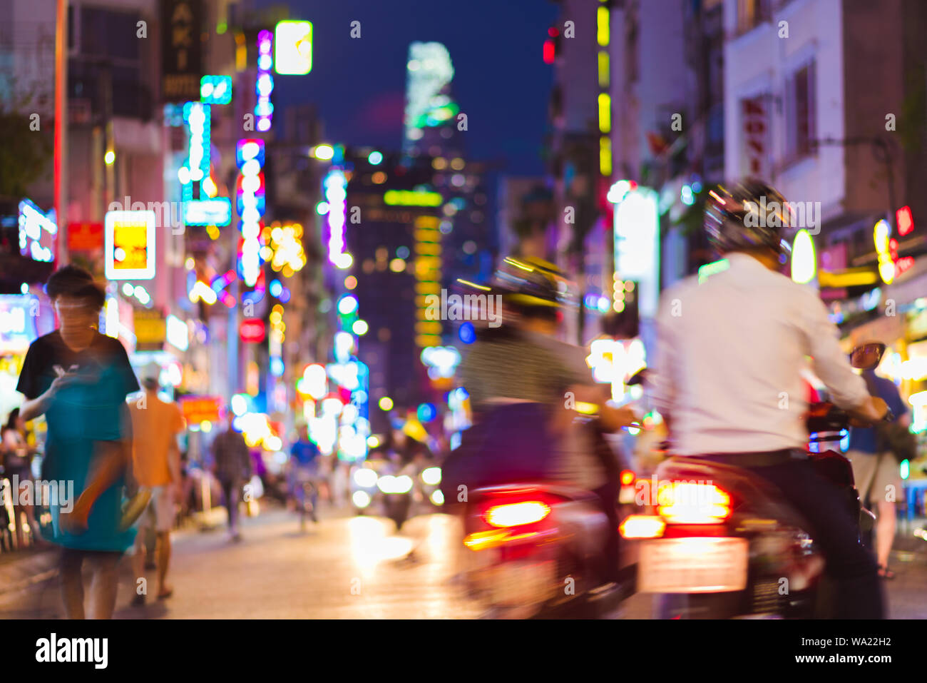 Desenfocado borroso escena colorida de la calle la noche de perspectiva con motocicletas borrosa, transeúntes, letreros y todo tipo de luces de neón. Saigón. Foto de stock