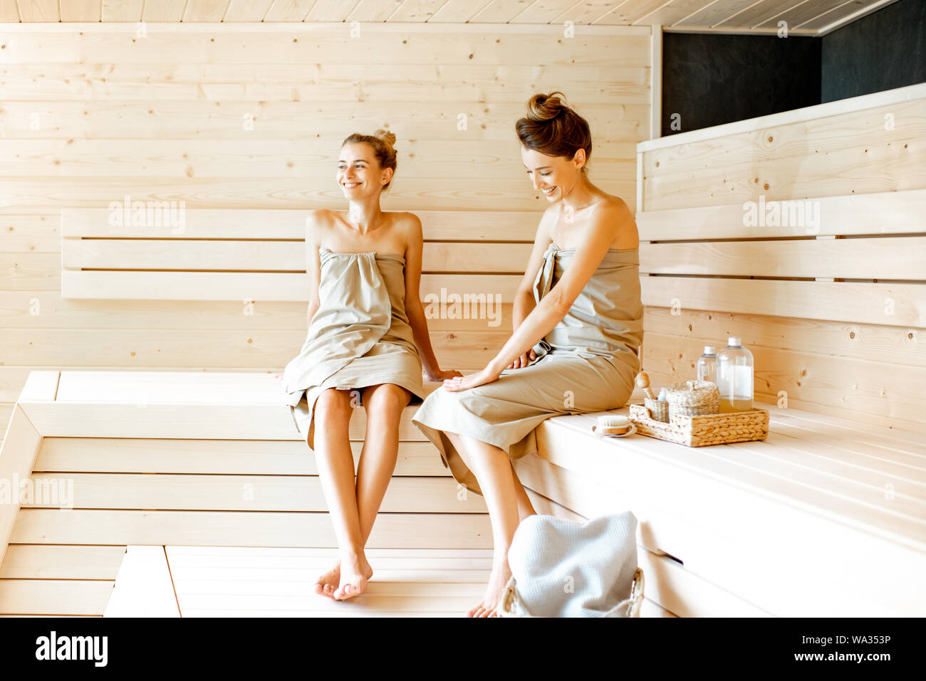 Dos Muchachas Se Están Sentando En Una Sauna Finlandesa Imagen de archivo -  Imagen de amigos, salud: 119493781
