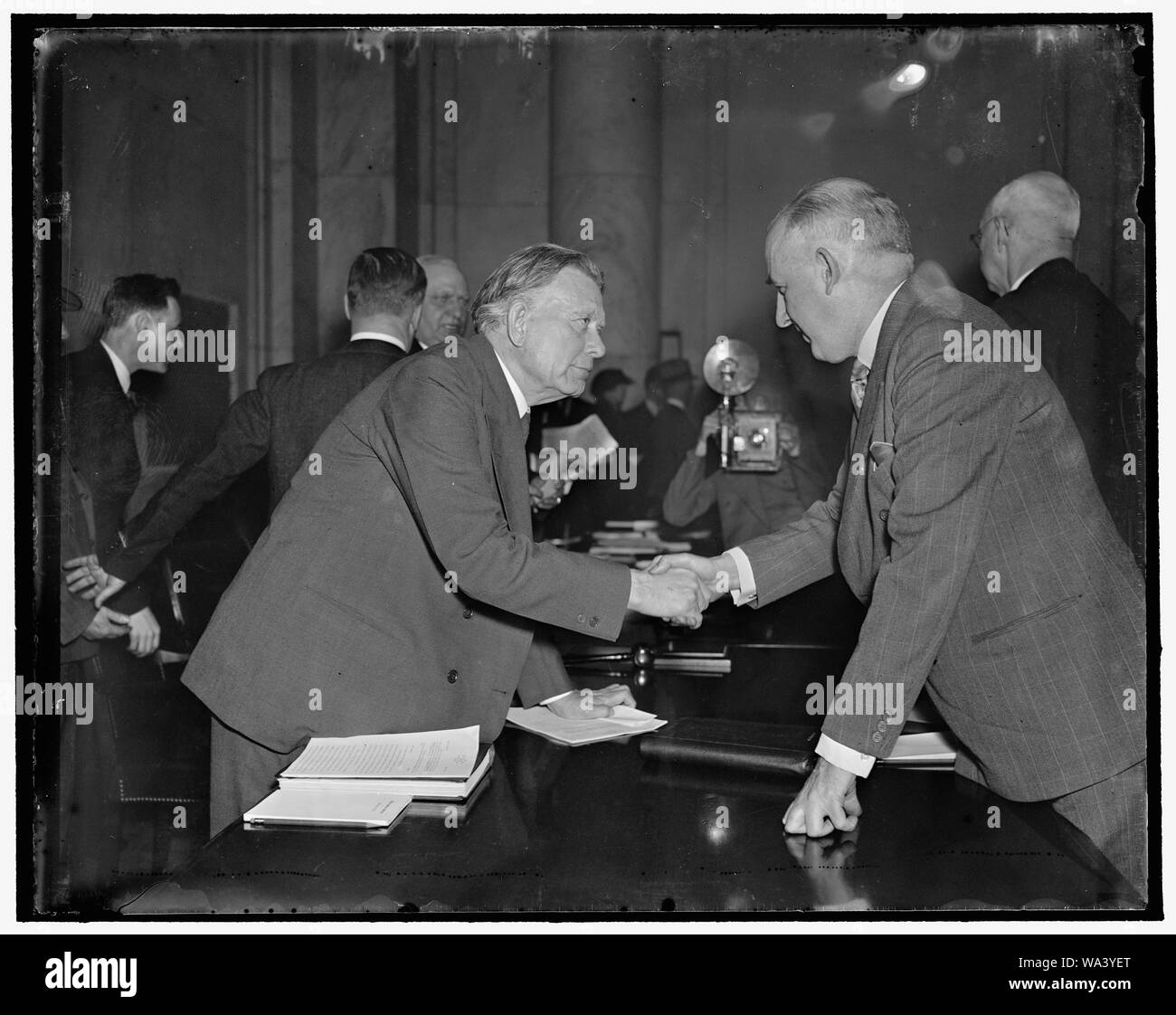 Borah Moley saluda. Washington, D.C., el 23 de marzo. El Senador William E. Borah, republicano de Idaho, saluda a Raymond Moley, ex miembro de la ace Roosevelt brain trust como llegó a expresar su oposición al plan de reforma judicial del presidente ante el Comité Judicial del Senado, 23/03/1937 Foto de stock