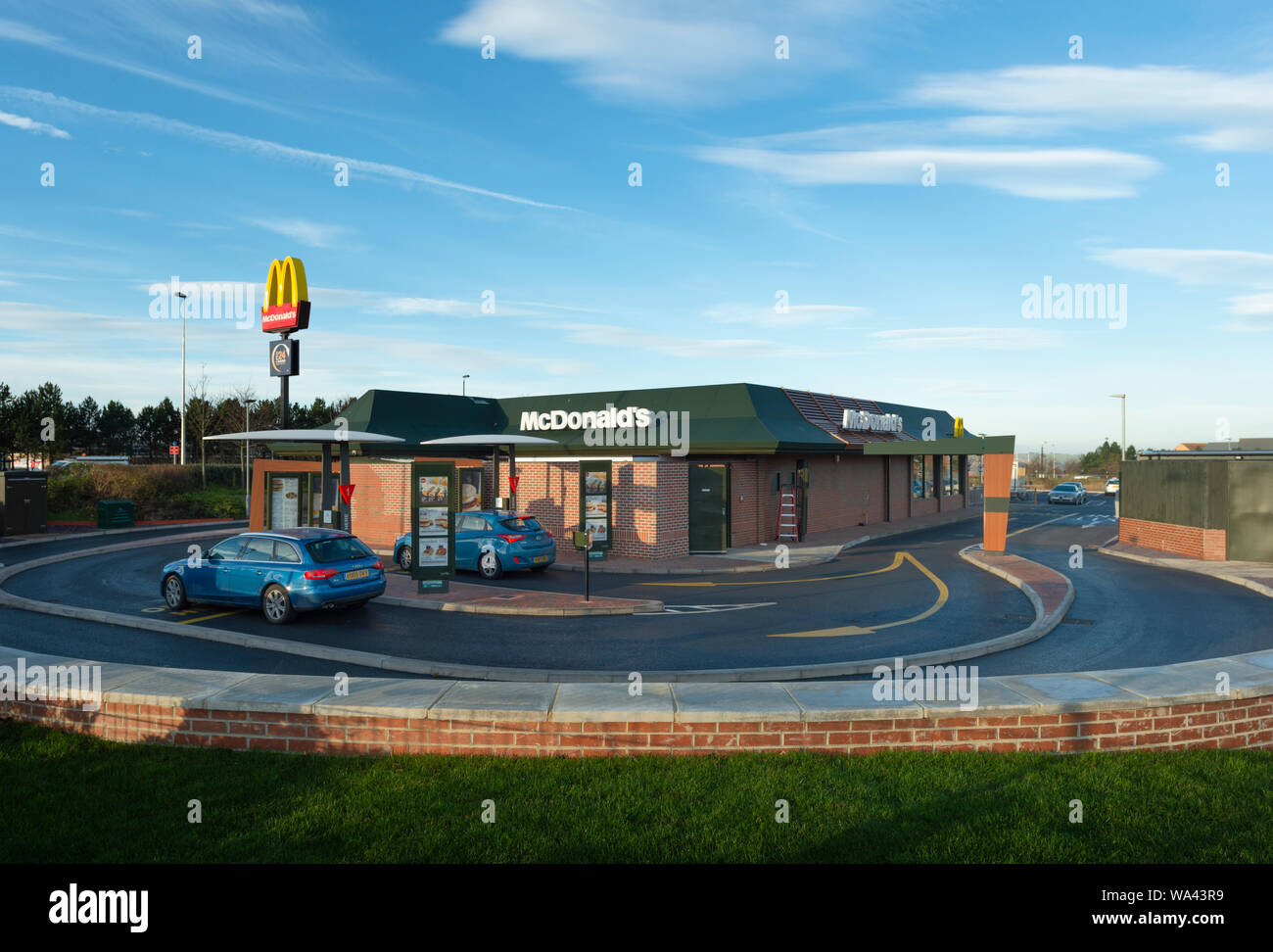 Coches esperando para ser servido comida para llevar en un restaurante de comida rápida McDonalds Foto de stock