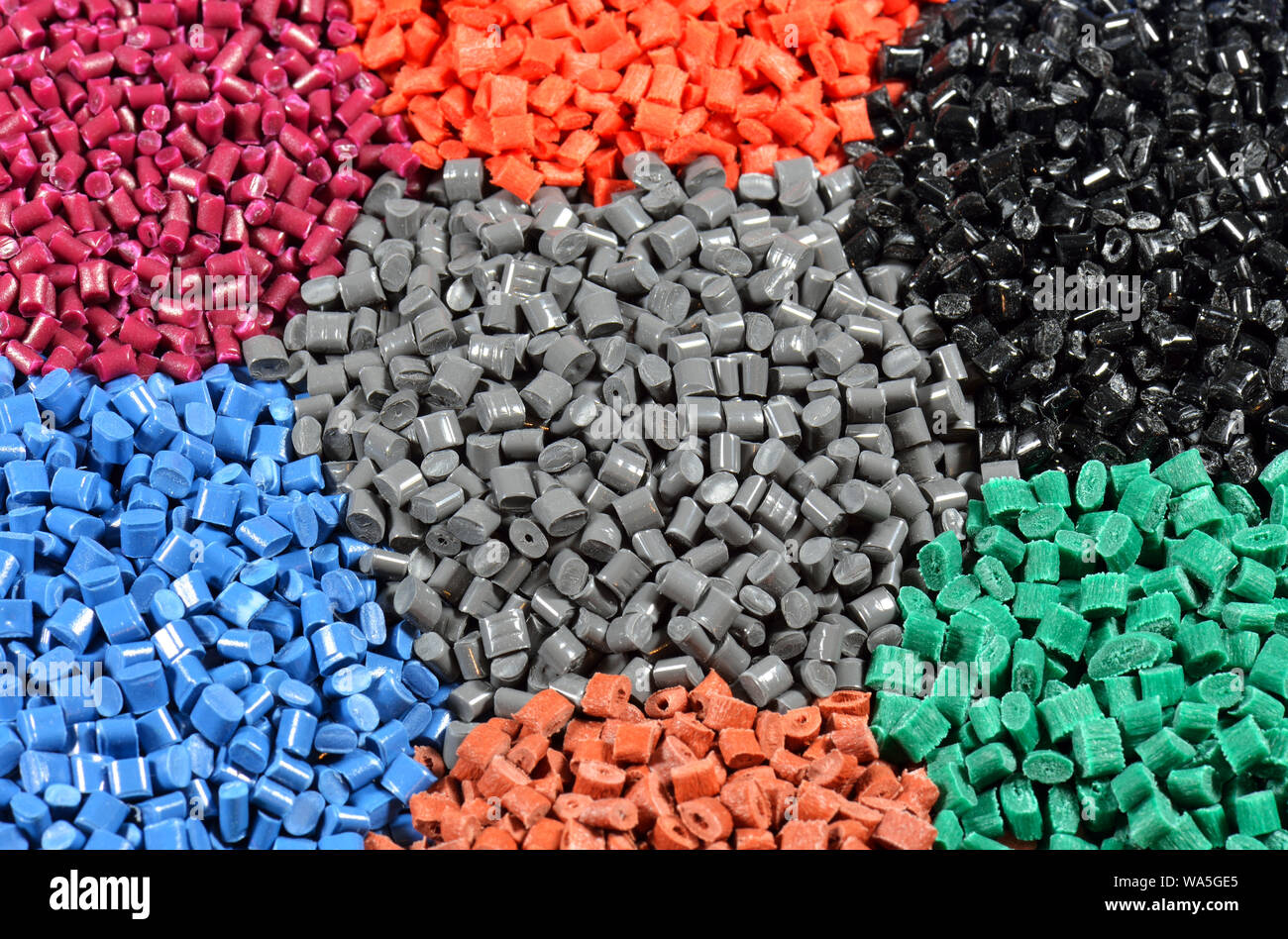 Gránulos de polímero tintados en diferentes colores. Foto de stock