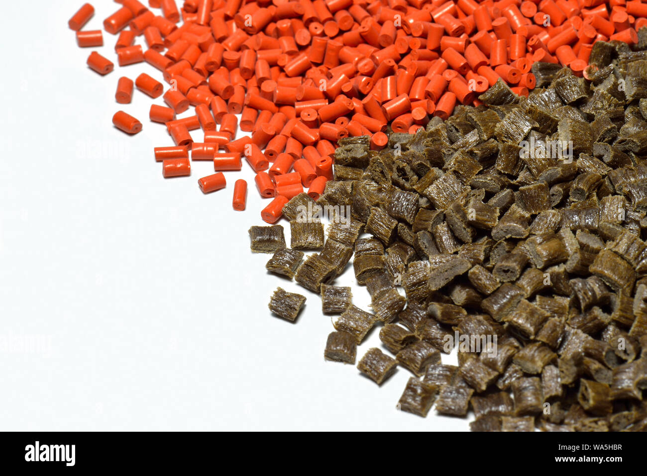 Gránulos de polímero de color naranja y marrón para el proceso de moldeo por inyección Foto de stock