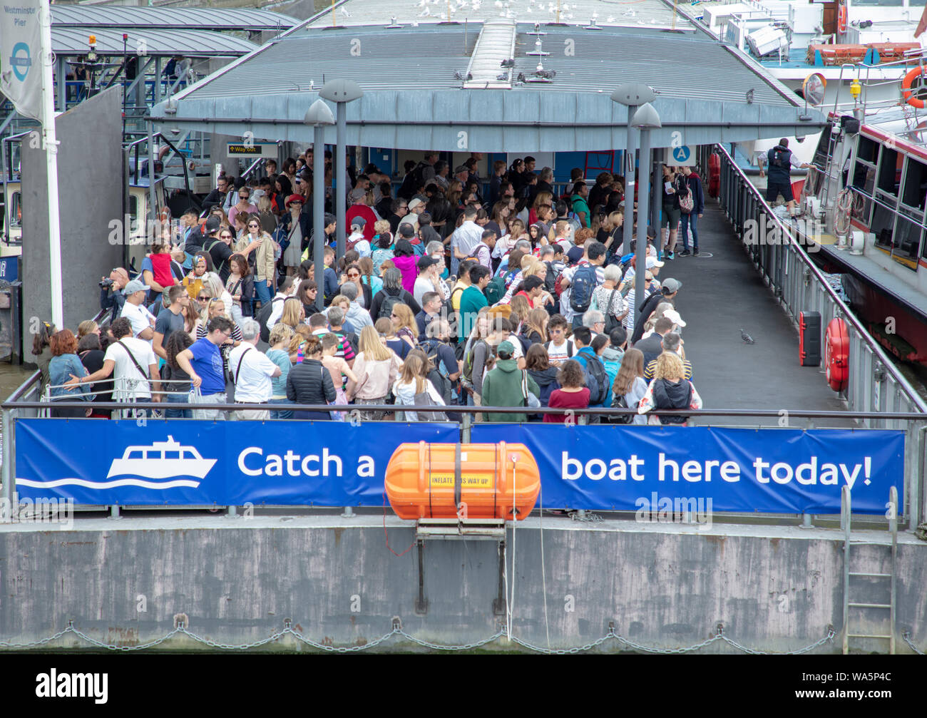 Los turistas esperando para emprender un crucero por el río Támesis por un corto viaje por el río para ver algunos de los lugares más emblemáticos de Londres. Foto de stock