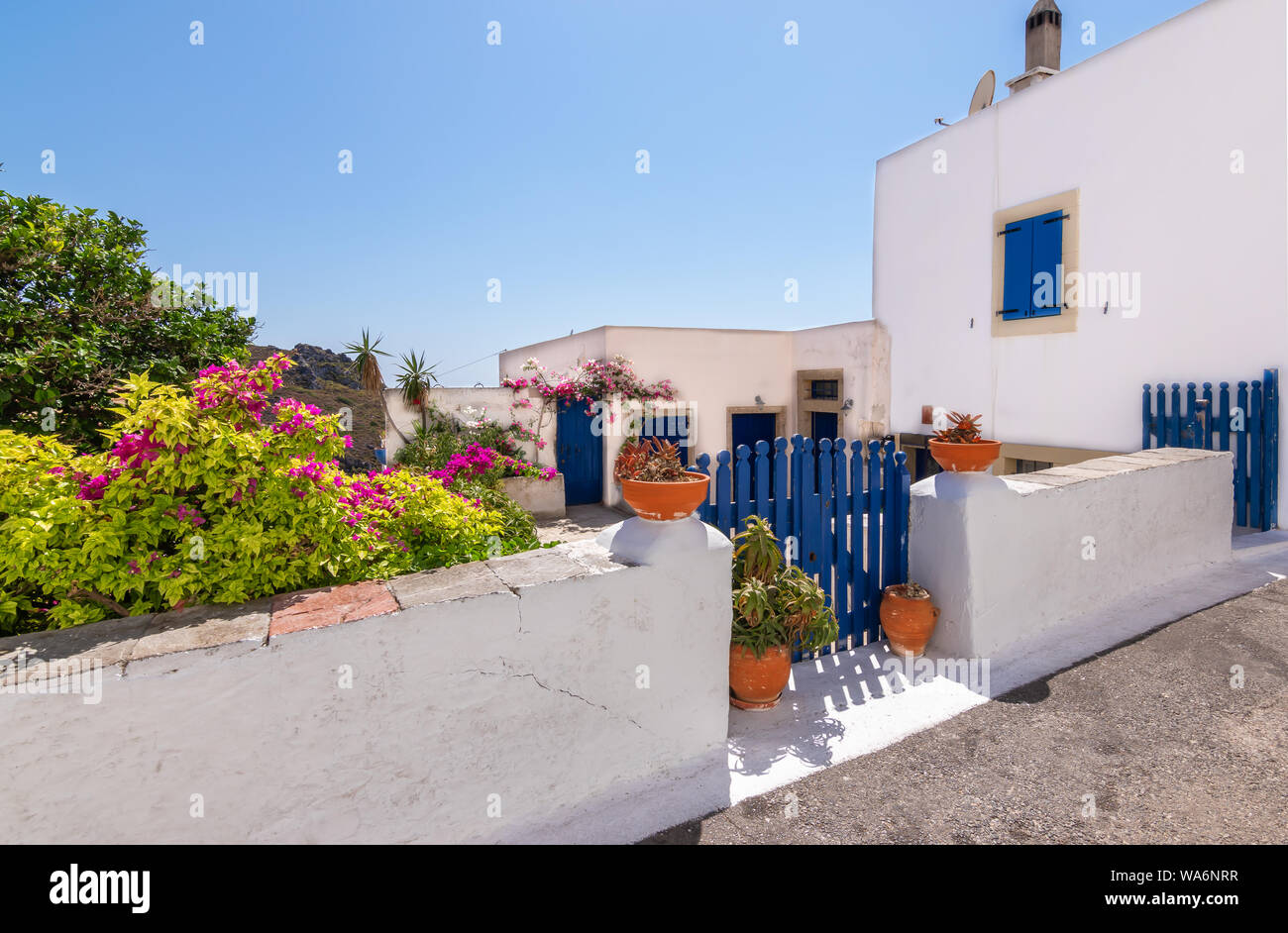 Ciudad de Chora con blanco casa griega, el patio y la cerámica decorativa a lo largo de la calle, la isla de Citera, Grecia. Foto de stock