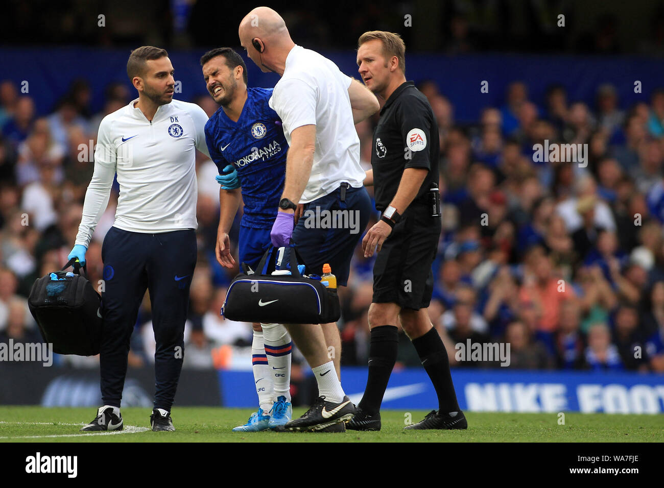 Pedro de Chelsea (2L) es ayudado fuera de la cancha lesionado por el equipo  médico de Chelsea. Premier League, Chelsea v Leicester City en Stamford  Bridge en Londres el domingo 18 de
