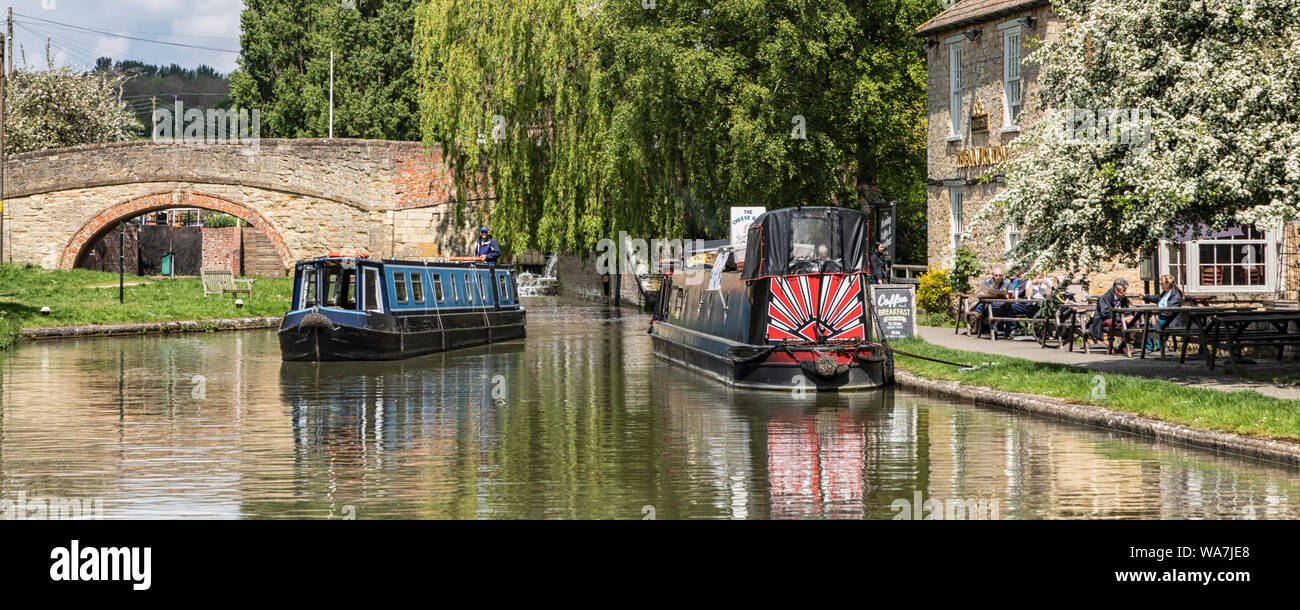 STOKE BRUERNE, Northamptonshire: Narrowboats junto a la navegación Inn pub y puente en el Grand Union Canal Foto de stock