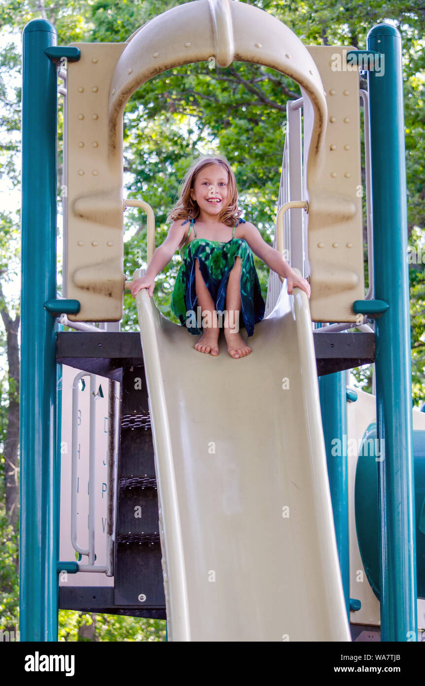 Chica desnuda en una diapositiva alto jugando en un parque infantil  Fotografía de stock - Alamy
