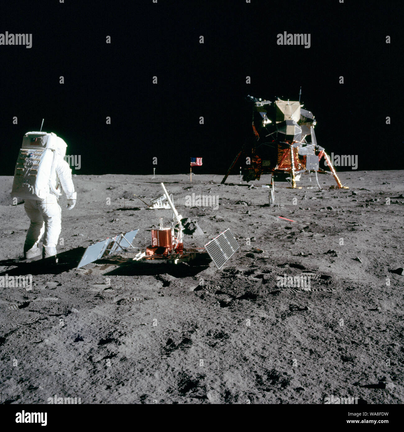 El astronauta Edwin E. "Buzz" Aldrin, Jr., piloto del Módulo Lunar, es fotografiado durante la actividad extravehicular Apolo 11 en la Luna. Él ha desplegado los primeros experimentos científicos Apollo Package (EASEP). En el primer plano es el experimento sísmico pasivo Package (PSEP); más allá está el Láser Retro-Reflector (LR-3); en el centro de fondo es la bandera de los Estados Unidos; en el fondo izquierdo es el blanco y negro de la superficie lunar cámara de televisión; en el extremo derecho de fondo es el módulo lunar "Eagle". El astronauta Neil A. Armstrong, comandante, tomó esta fotografía con un 70mm s lunar Foto de stock