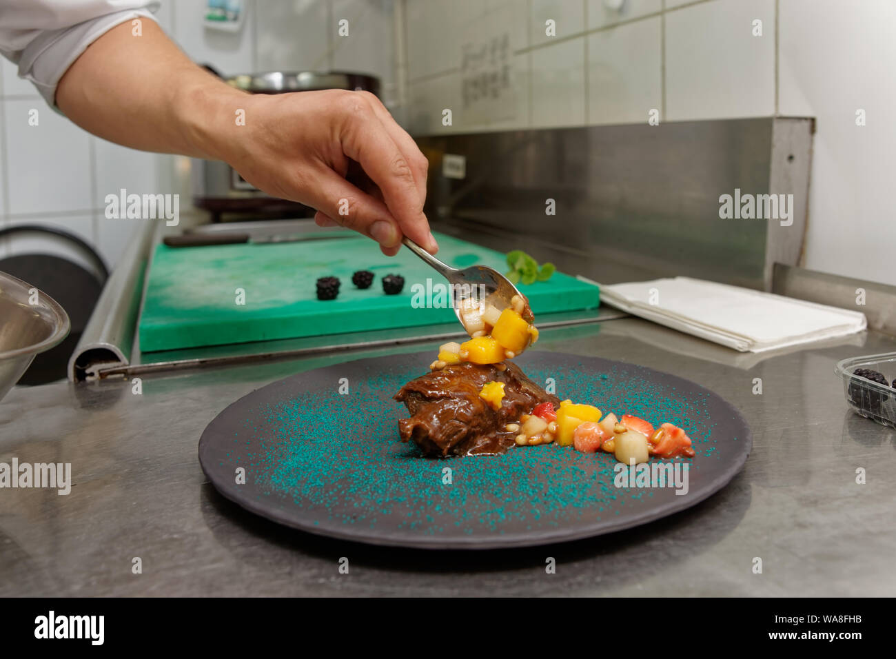 Chef es decorar estofado de carne de ternera con salsa de frutas, cocina  comercial Fotografía de stock - Alamy