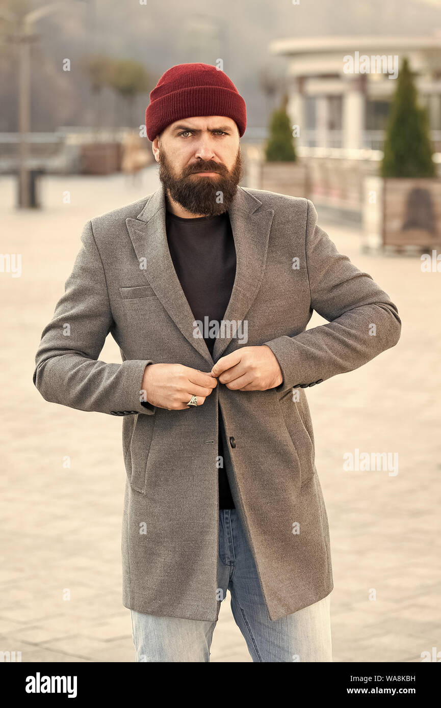 El abotonarse la chaqueta. Hipster traje y sombrero accesorio. Atuendo informal  elegante temporada de primavera. Ropa y concepto de moda masculina. El  hombre barbado hipster moda elegante abrigo y sombrero. Ropa cómoda