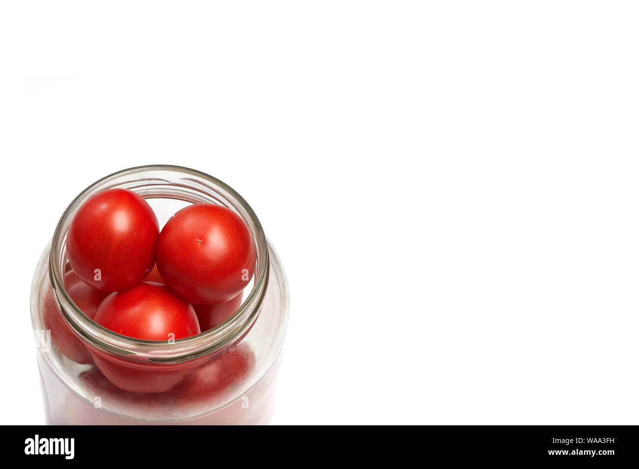 Tomates rojos apilados en un tarro secanar, preparación para enlatar. Espacio para el contenido o texto Foto de stock