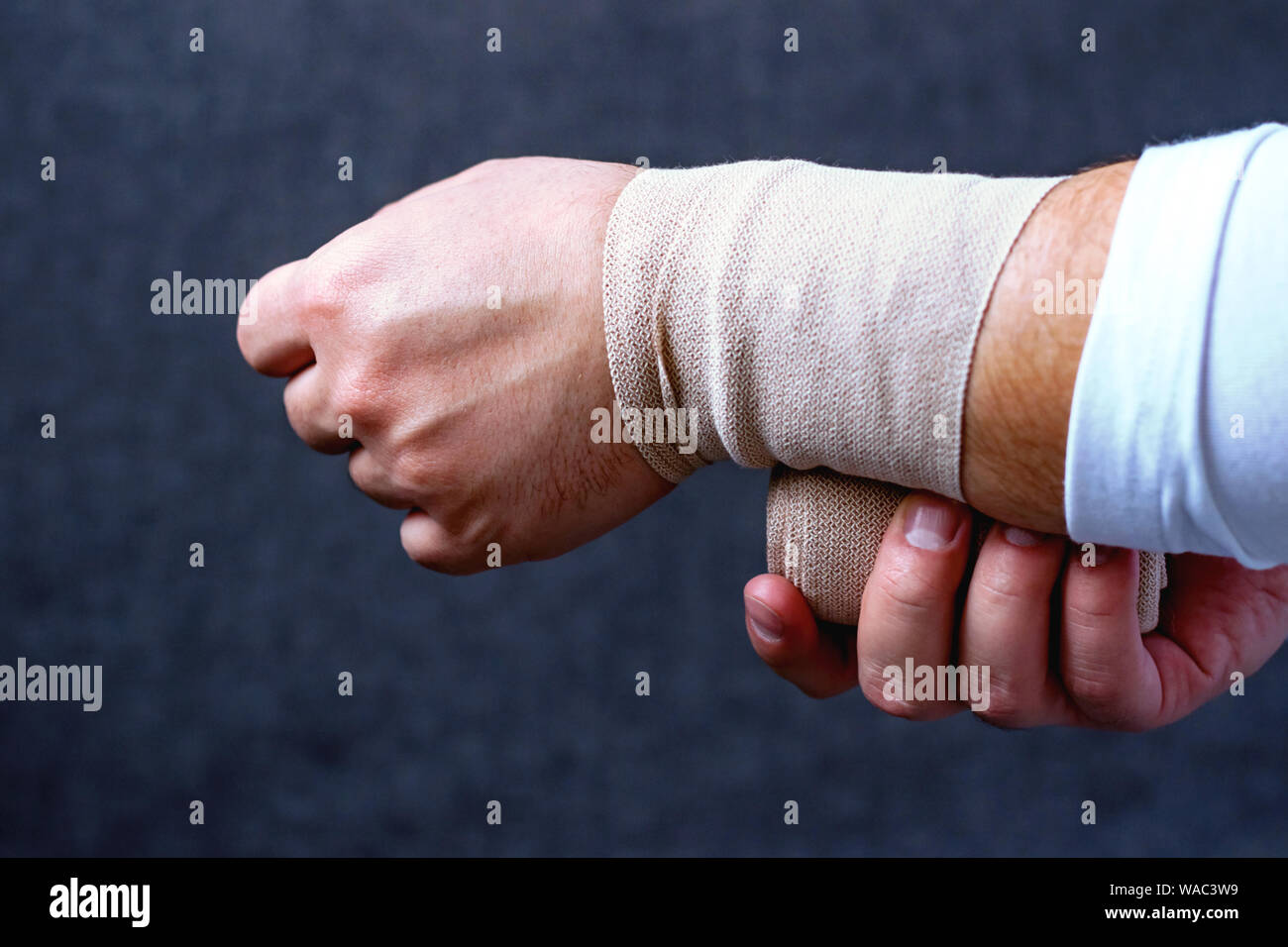 Un hombre vendas su mano con un vendaje deportivo. Las lesiones y las cepas  en deportes Fotografía de stock - Alamy