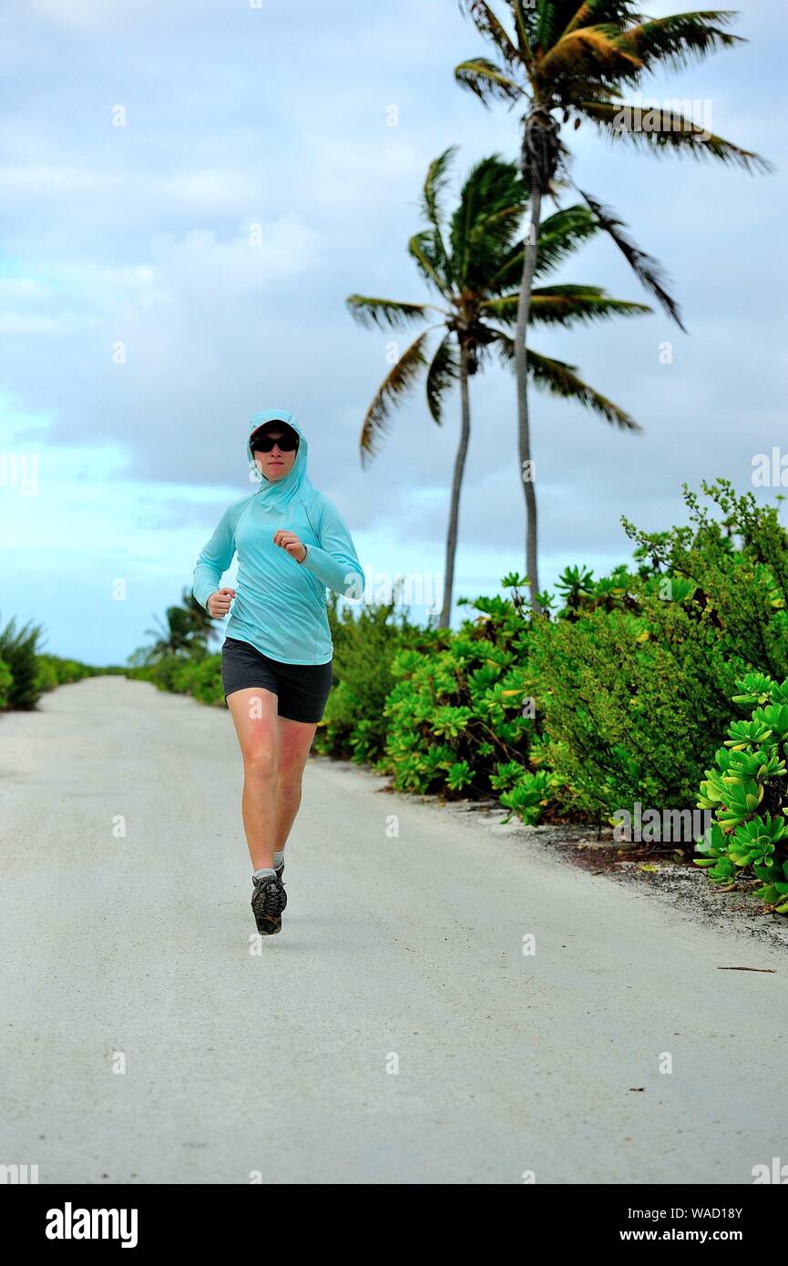 Mujer joven corriendo en un camino en la Isla de Navidad Foto de stock