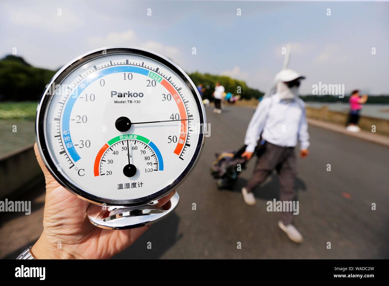 Un residente local muestra un termómetro que muestra la temperatura actual  de alcanzar 40 grados centígrados en el paisaje de los lagos del oeste de  la ciudad de Hangzhou, EAS Fotografía de