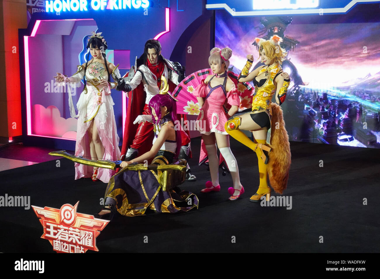Animadores vestidos de cosplay disfraces con los personajes de Tencent MOBA móvil del "Rey de la gloria" o "Honor de Reyes' plantean en un pop-up de exposición Foto de stock