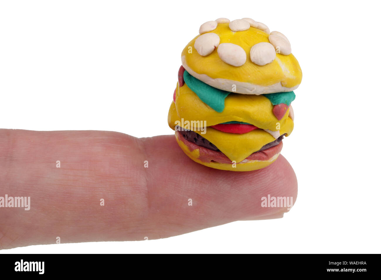 En el futuro vamos a comer este concepto - mini hamburguesas hechas de  arcilla plastilina en el dedo. Aislado en blanco studio macro Fotografía de  stock - Alamy