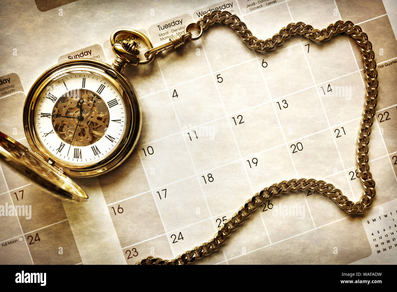La gestión del tiempo, reloj de bolsillo de oro sobre fondo de calendario en blanco Foto de stock