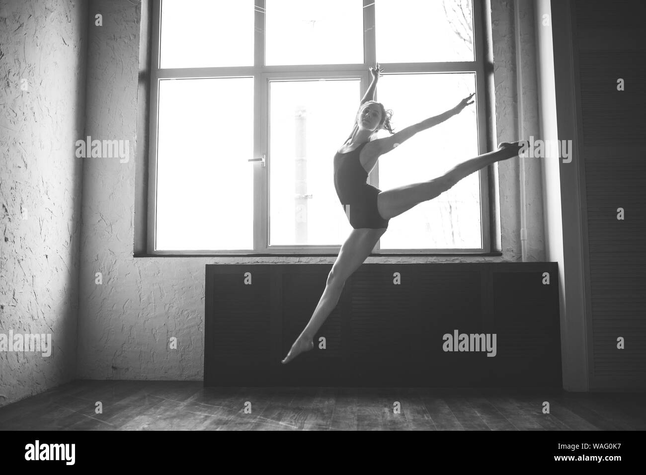 Plasticidad delgada mujer bailando cerca de la ventana. Bailarina profesional disfrutar de la danza. Lady Dancer formación Ballet moderno en clase. Bailador contemporáneo Foto de stock