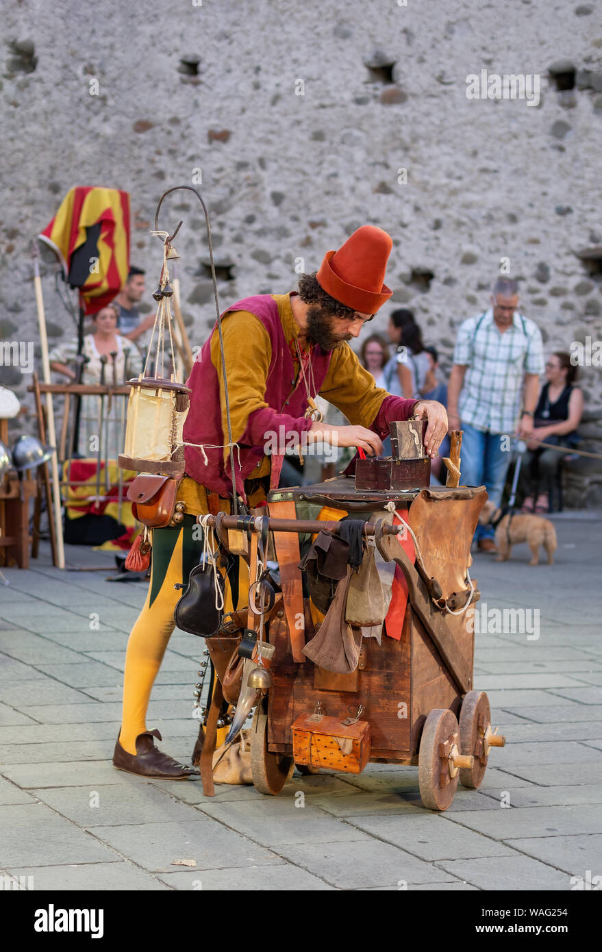 FILETTO, Italia - Agosto 11, 2019: un mago bufón busca algún elemento en su caja de trucos. Fiestas del pueblo en una auténtica aldea medieval Foto de stock