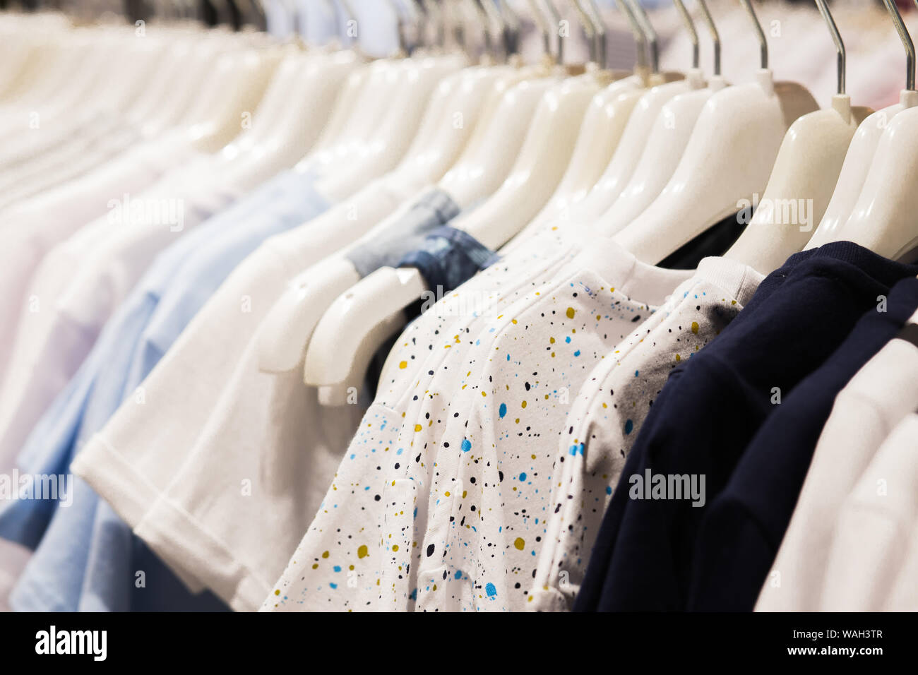 La percha está lleno de coloridas telas camisas .Limpiar las camisas  colgadas en rack en lavandería, closeup Fotografía de stock - Alamy