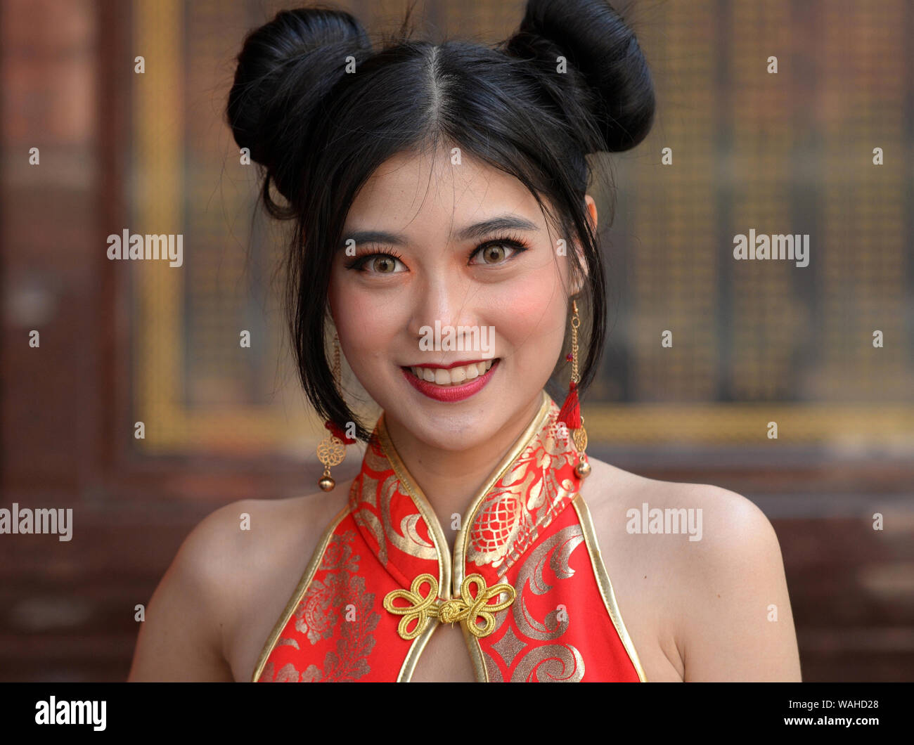 Joven Chino Tailandés belleza con lindo Chun Li doble bollos cabello luce  un elegante rojo y dorado (vestido chino cheongsam) y posa para la cámara  Fotografía de stock - Alamy