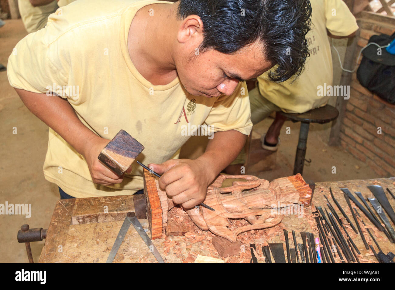 En Siem Reap, Camboya. Joven tallando figuras de madera de árbol de caucho a los artesanos de Angkor, un taller en el que se capacita a jóvenes incultos y discapacitados jóvenes camboyanos en la artesanía. (Uso Editorial solamente) Foto de stock