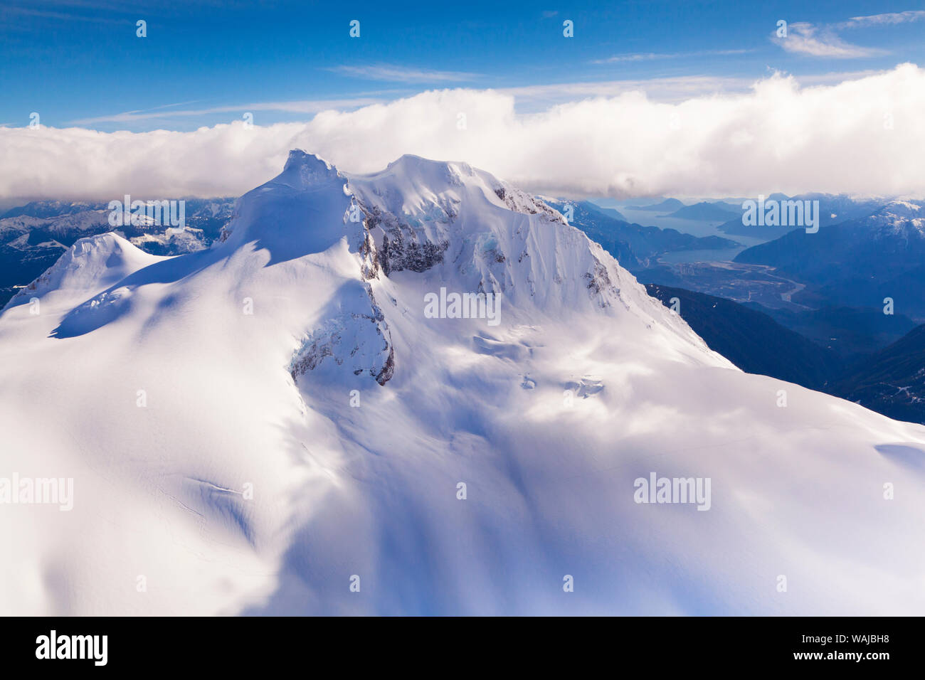 Vista aérea con el Monte Garibaldi en primer plano, con Howe Sound y Squamish en el fondo. British Columbia, Coast Mountains, Canadá Foto de stock