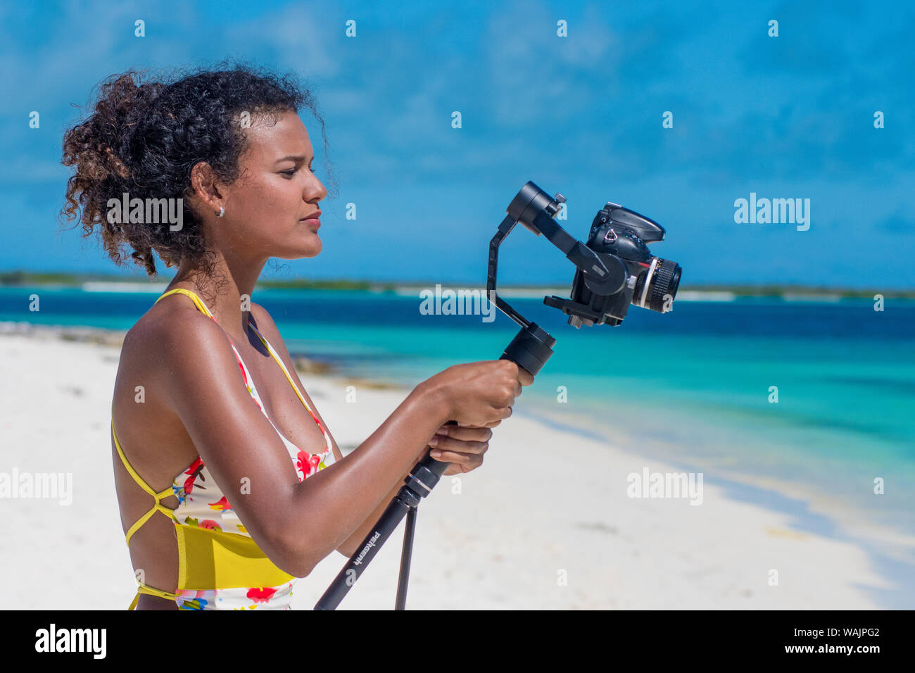 mujer joven latina en la playa vlogging filmación para youtube uso cámara gimbal Foto de stock