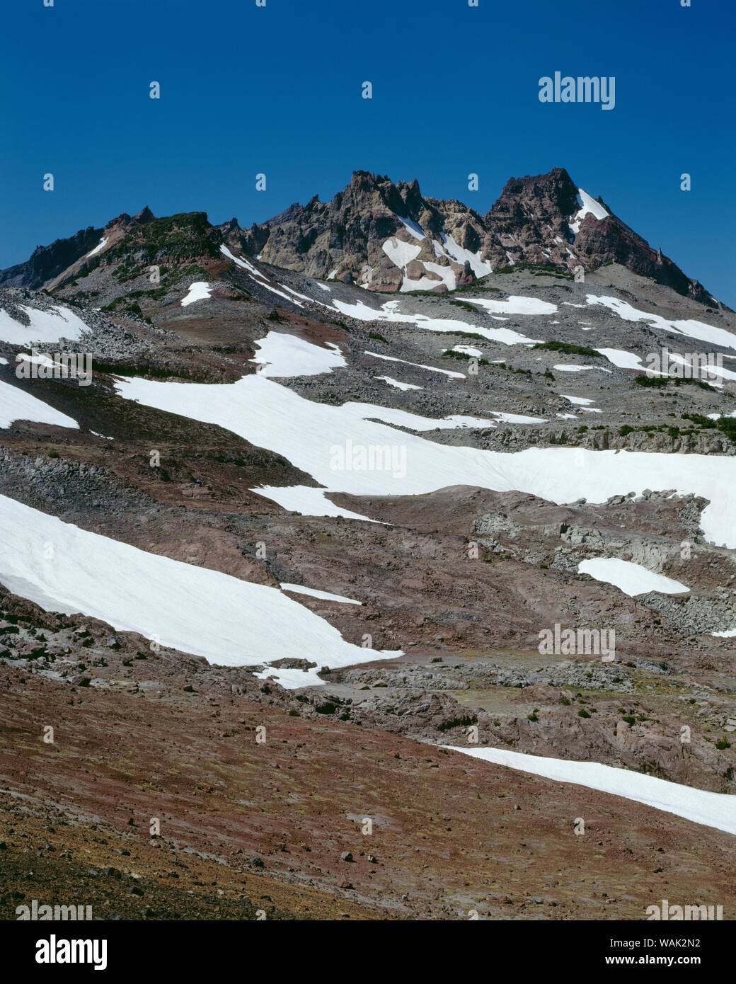 USA, Oregon, Deschutes National Forest. Tres Hermanas Desierto, roto arriba y la persistencia de la nieve del invierno anterior, vista al oeste de Tam McArthur Rim. Foto de stock