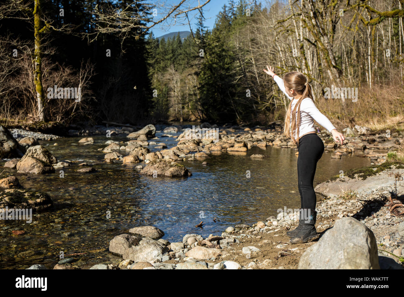 Olallie State Park, cerca de North Bend, en el estado de Washington, EE.UU.. Niña de nueve años arrojando una piedra en el aire. (MR) Foto de stock