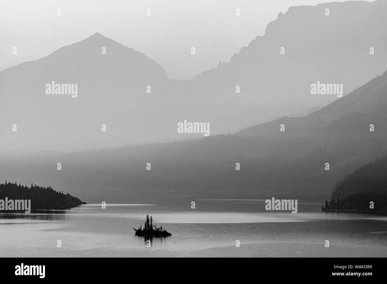 Wild Goose Island retroiluminada por smoky skies en el parque nacional de Glacier, Montana, EE.UU. Foto de stock