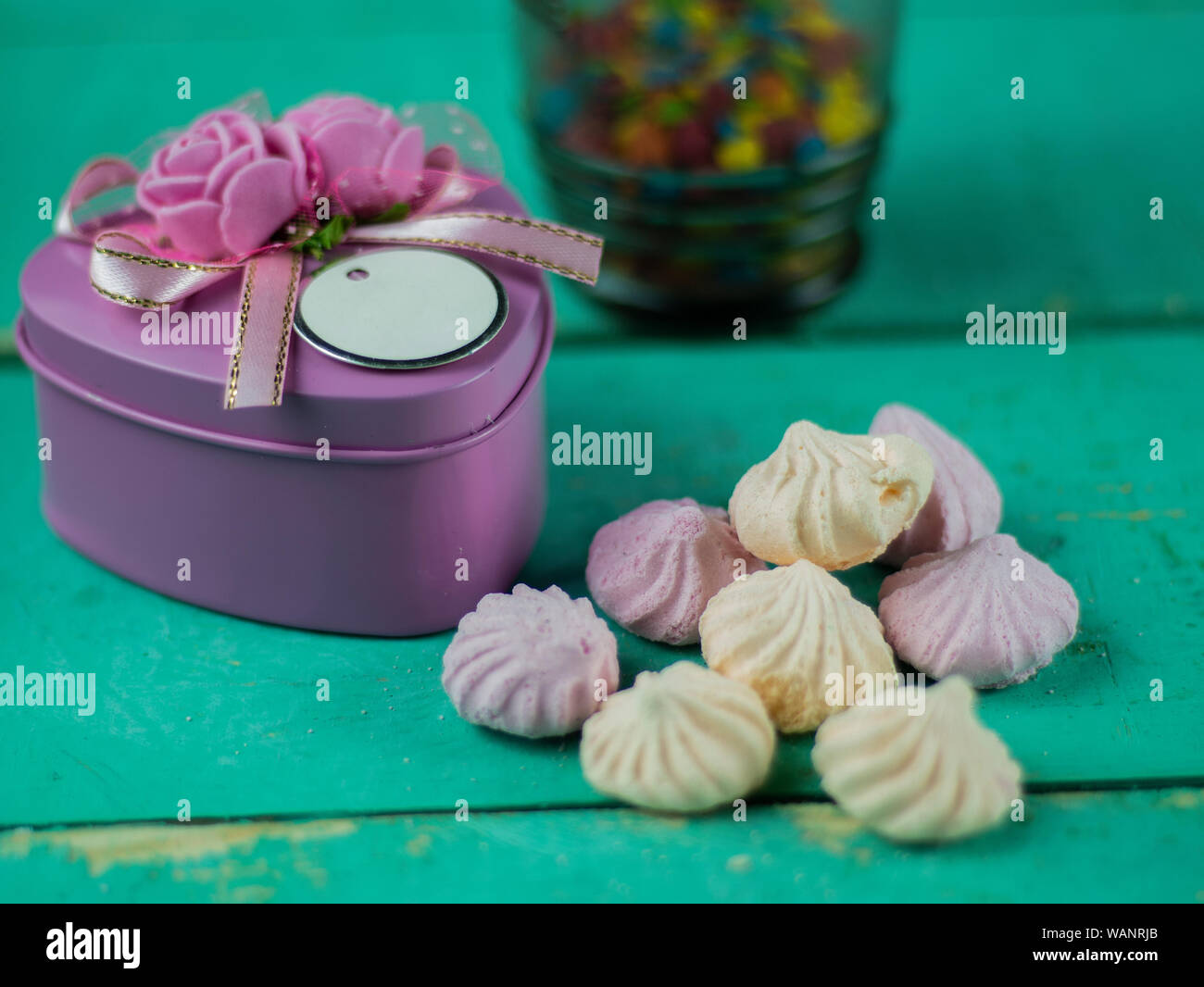 Caja en forma de corazón y merengues sobre un fondo de piedra Foto de stock