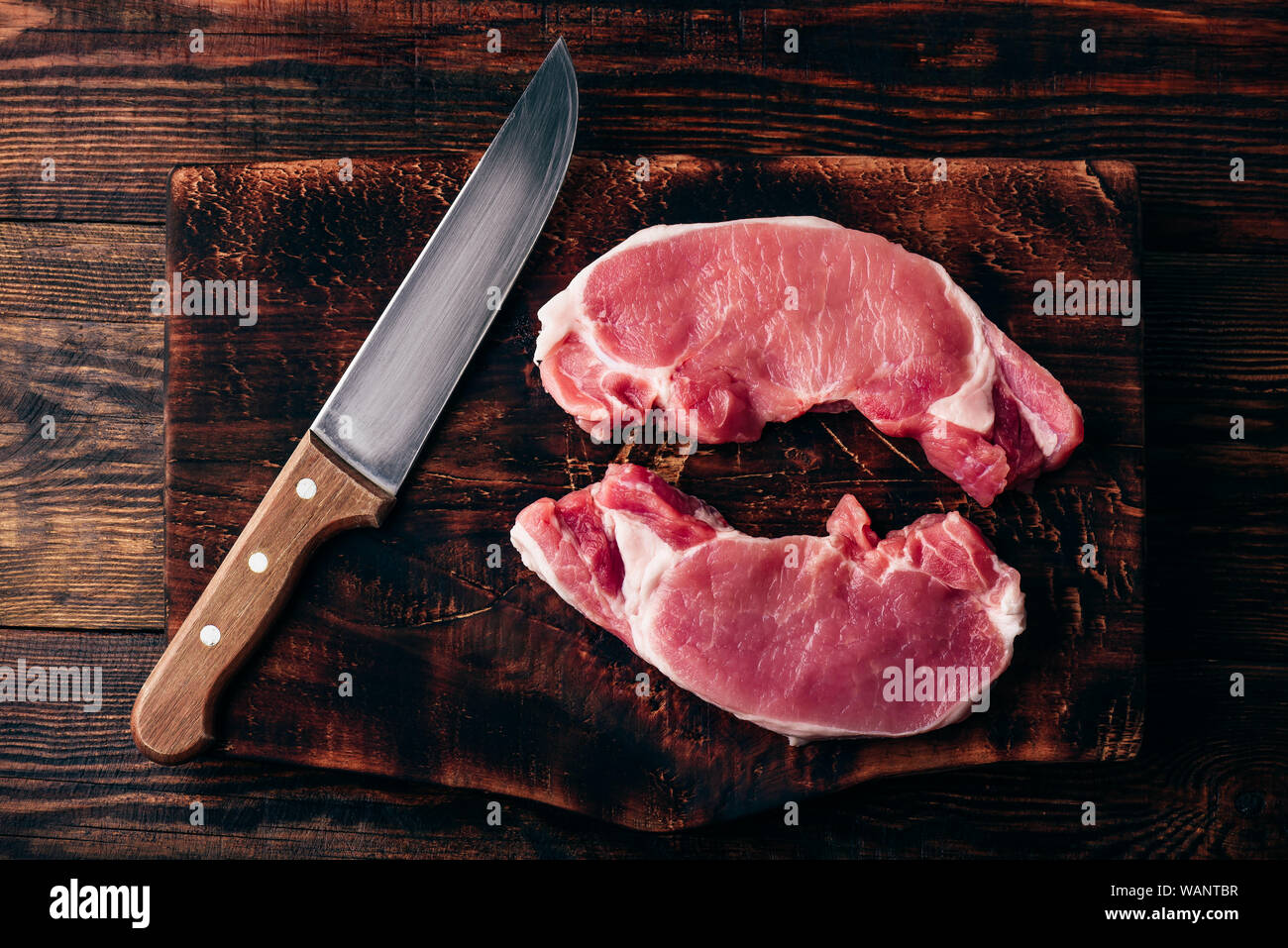 Dos filetes de lomo de cerdo con un cuchillo en la junta de corte rústico  Fotografía de stock - Alamy