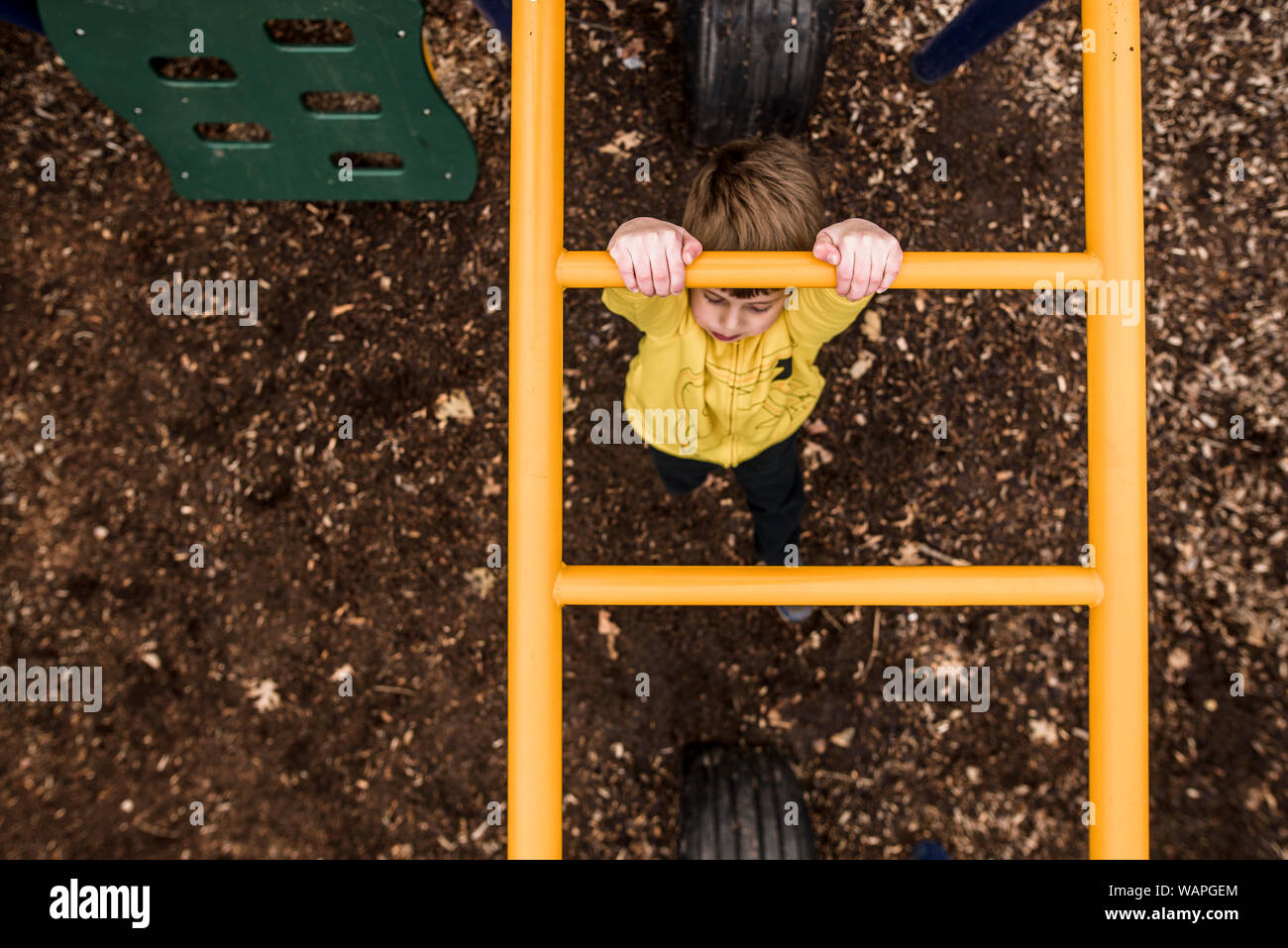 Mirando a la joven cruzando monkey bares en playground Foto de stock