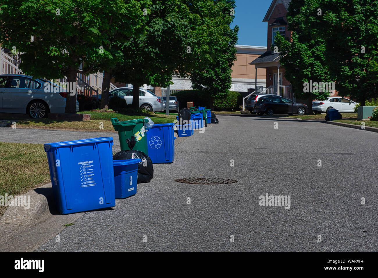 La basura, reciclaje y desechos de alimentos bandejas están a la espera de ser recogido en la parte delantera de las casas en la basura del día. Foto de stock
