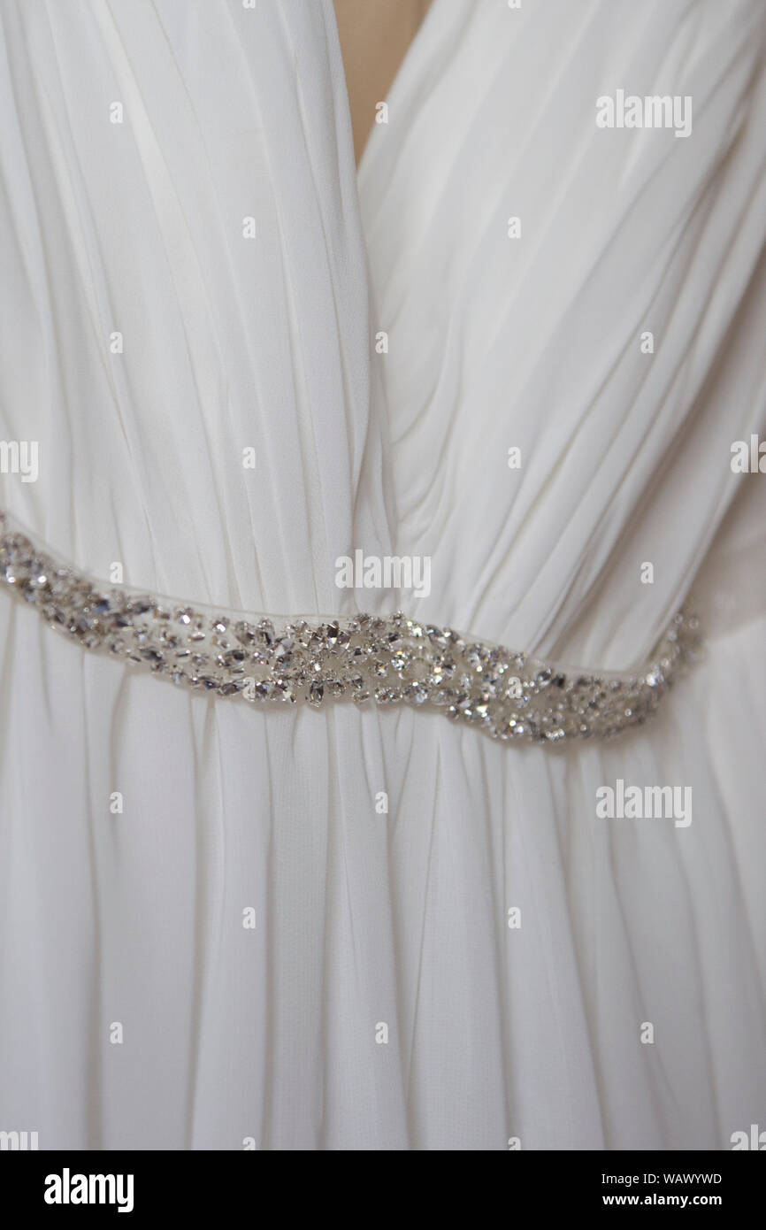 Cerca del vestido de bodas de plata con lentejuelas alrededor de la  cintura, en un día de boda, novias vestido está colgando a la espera de ser  desgastada Fotografía de stock -