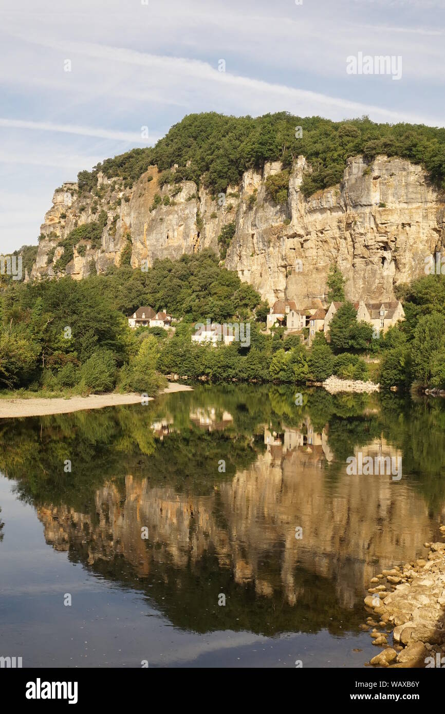 Acantilado de roca por encima del valle del río Dordogne con casas construidas en piedra Foto de stock