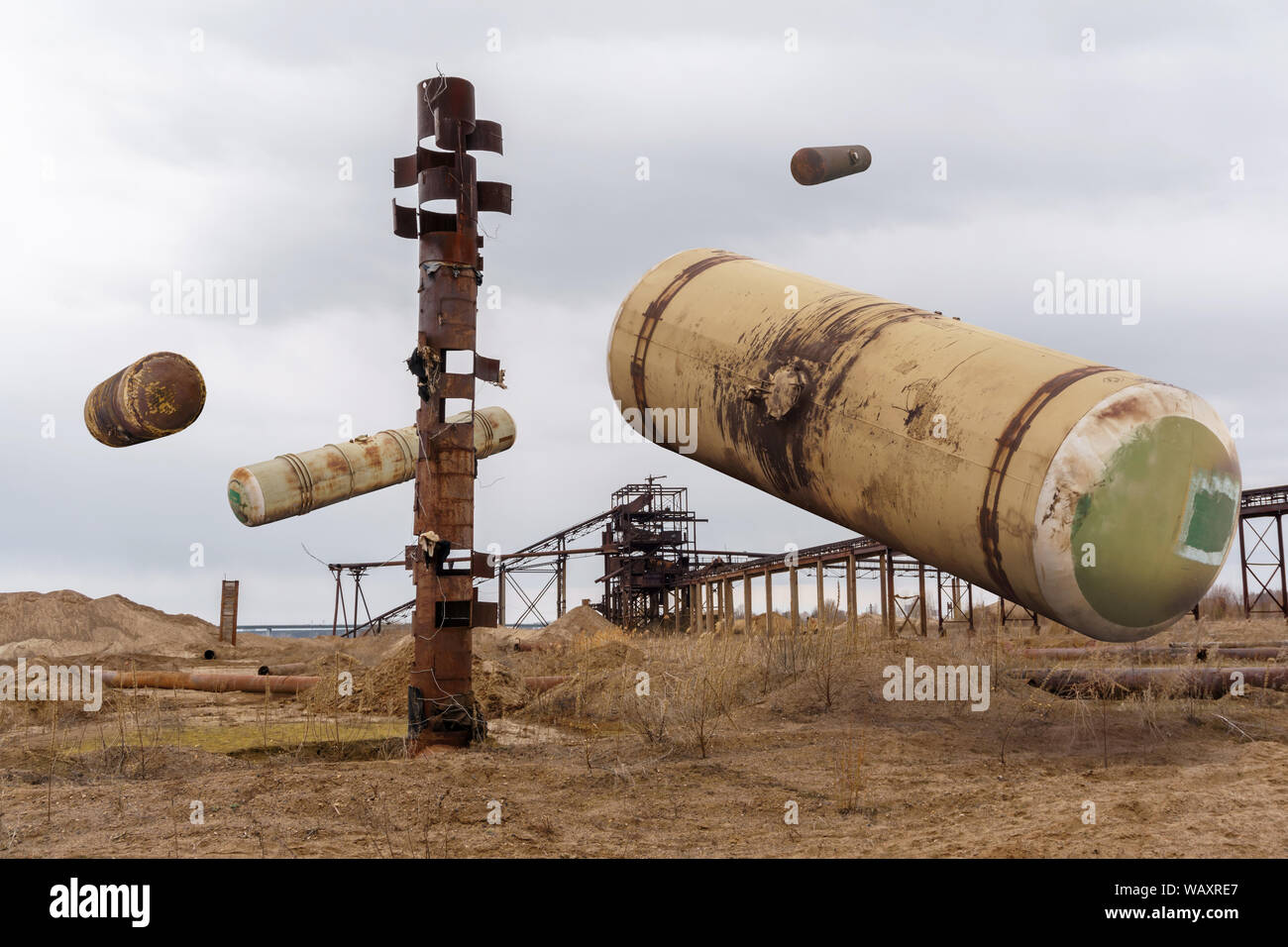 Paisaje surrealista con el viejo vagón tanques colgando en el aire sobre vertederos industriales, collage Foto de stock