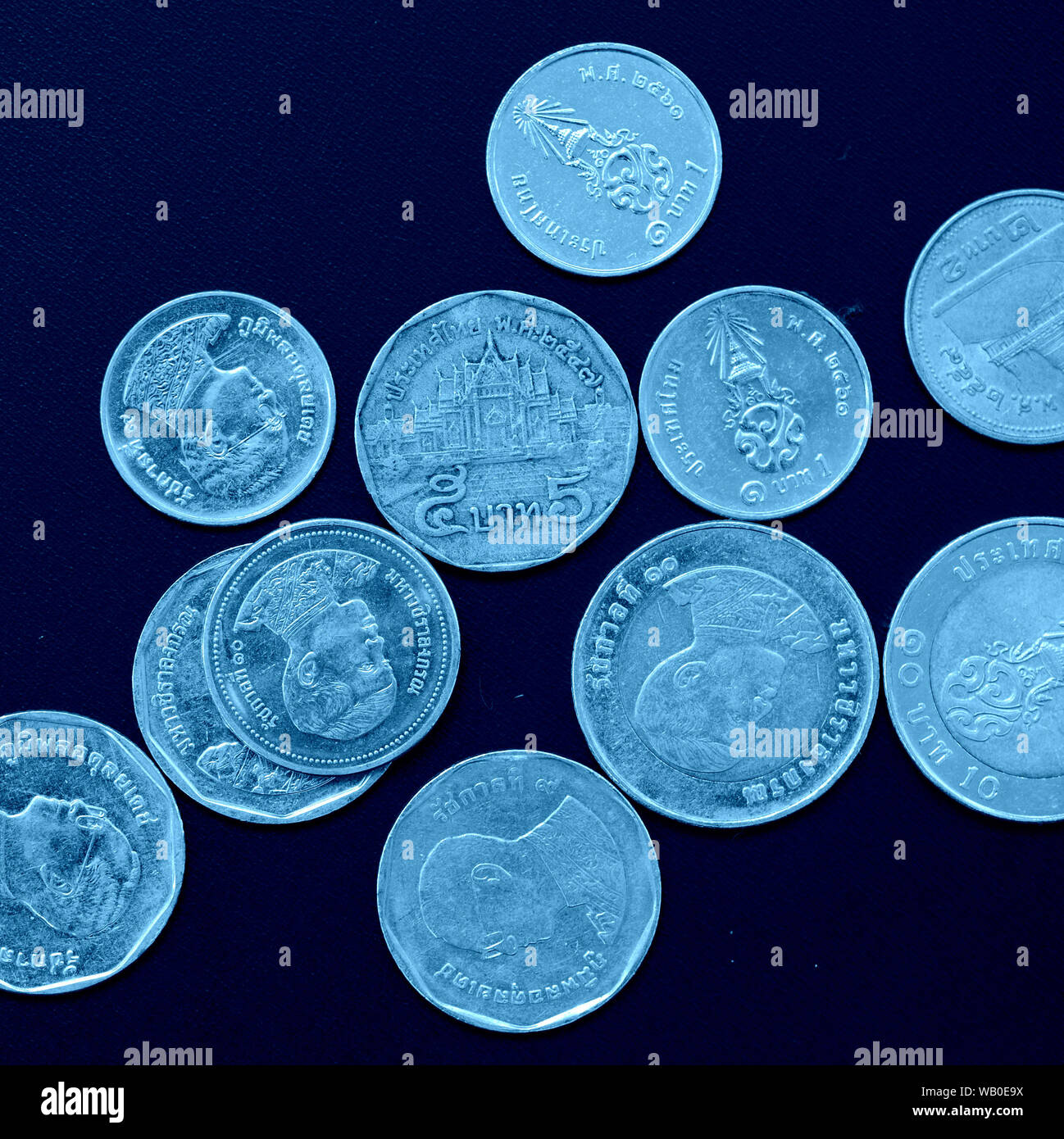 Thai Baht monedas cerca de tonos de color azul, vista superior, recortar cuadrados Foto de stock