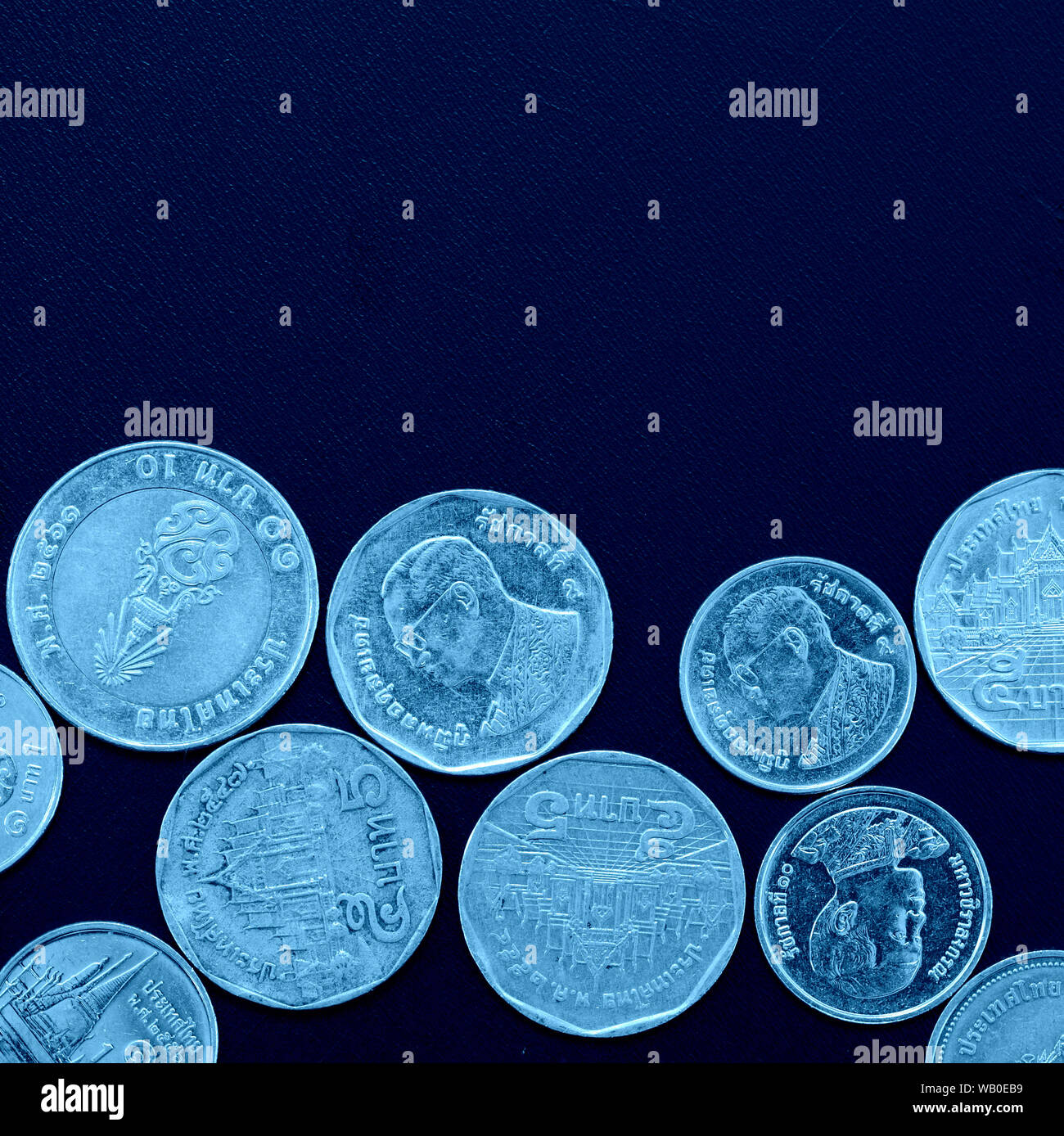 Thai Baht monedas cerca de tonos de color azul, vista superior, recortar cuadrados Foto de stock