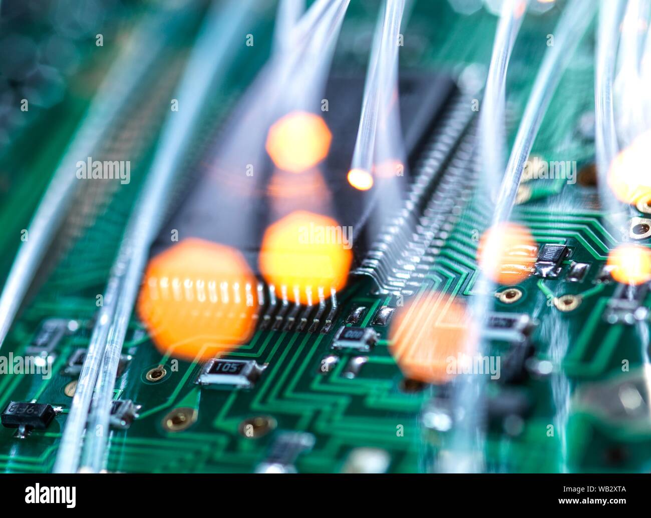 Comunicación digital, imagen conceptual. La fibra óptica transporta datos a través de circuitos electrónicos de un ordenador portátil. Foto de stock
