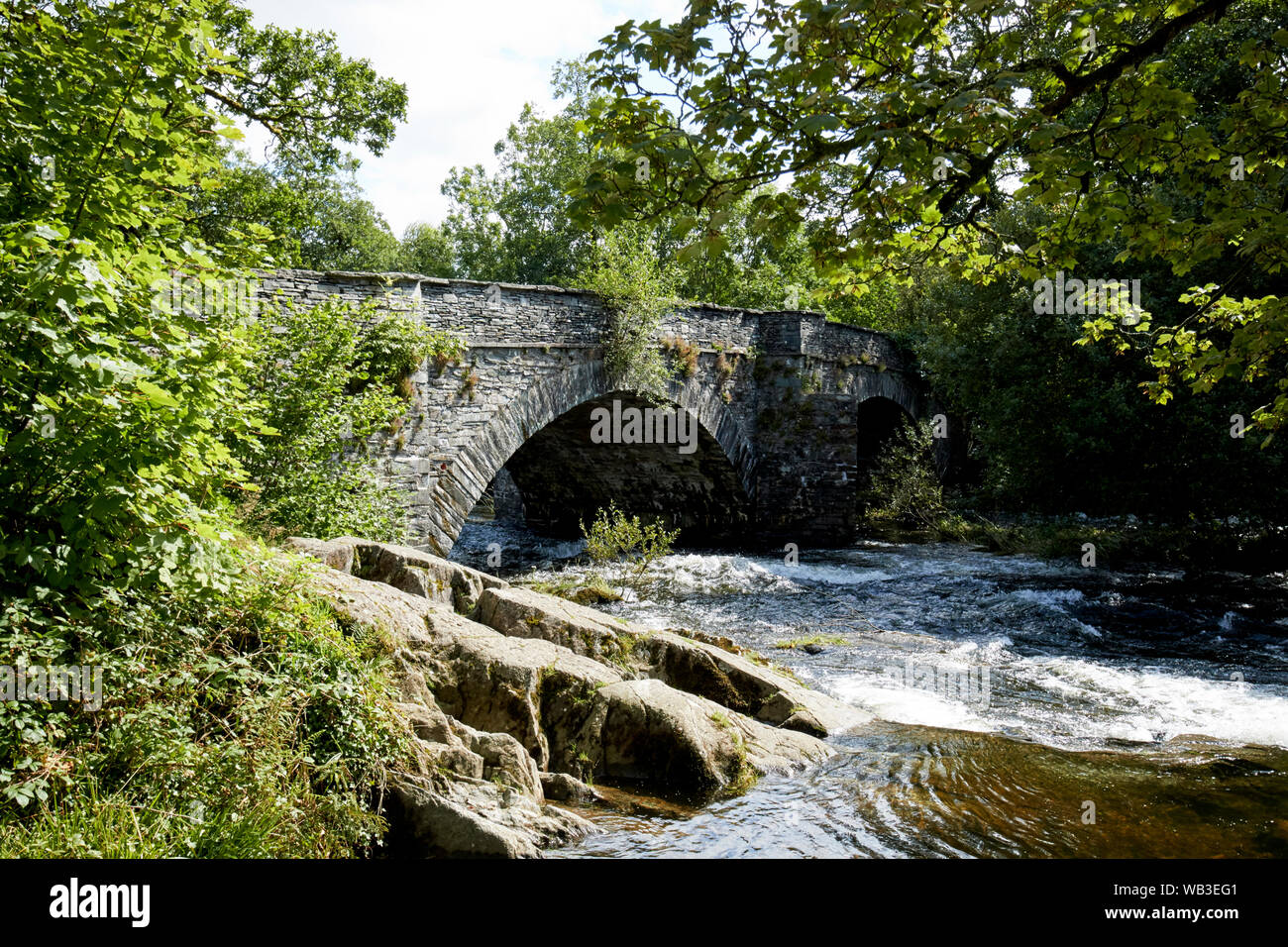 Los altos niveles del río que fluye bajo el puente Skelwith brathay en el Lake District National Park, Inglaterra, Reino Unido. Foto de stock