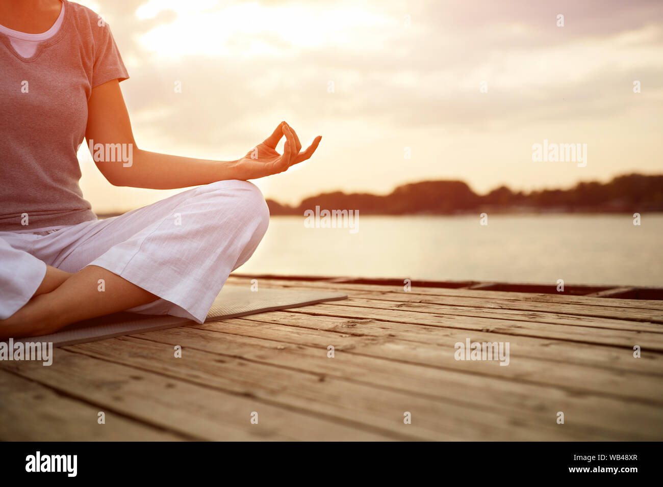 Mujer meditar en pose de yoga en Río, concepto Foto de stock