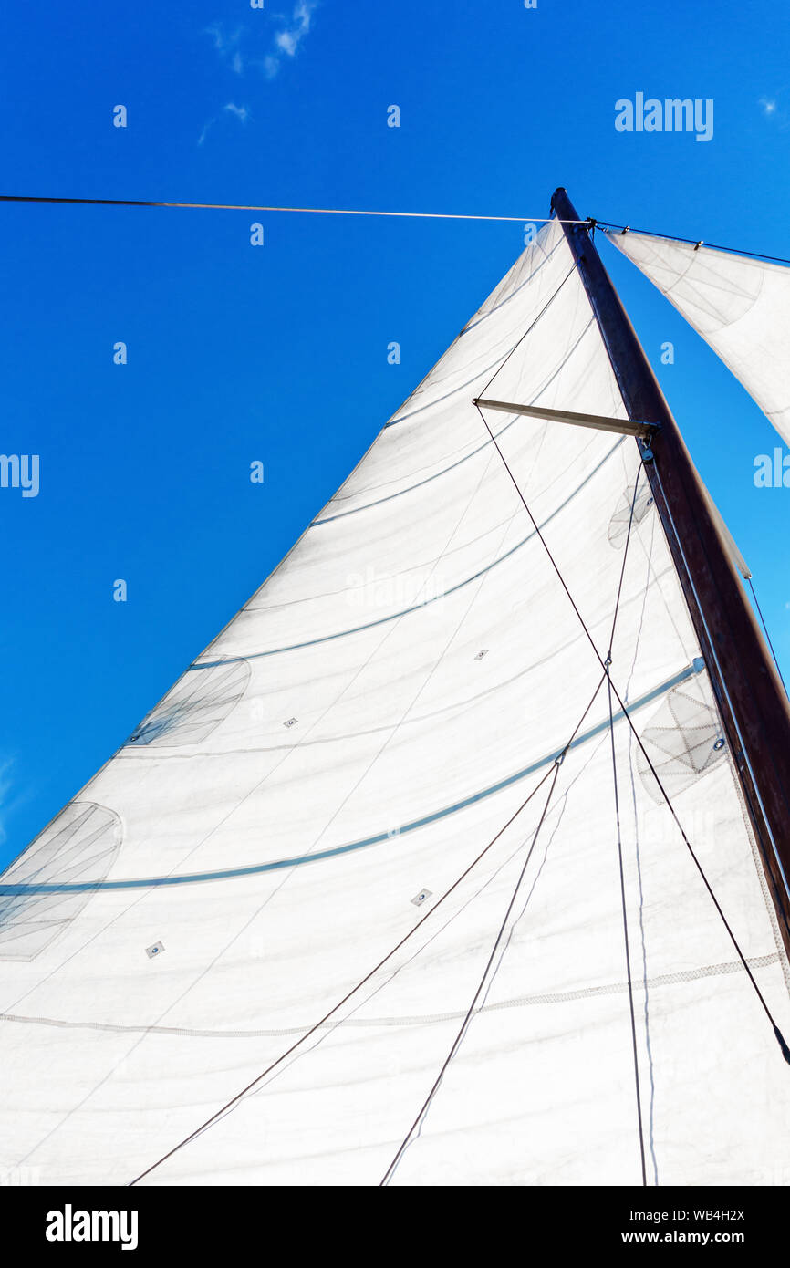 El mástil de un velero con las Bermudas equipos náuticos contra un cielo azul, vista de abajo arriba Foto de stock